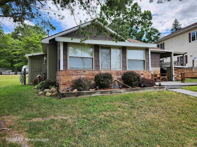 view of front of house with a front lawn and stone siding