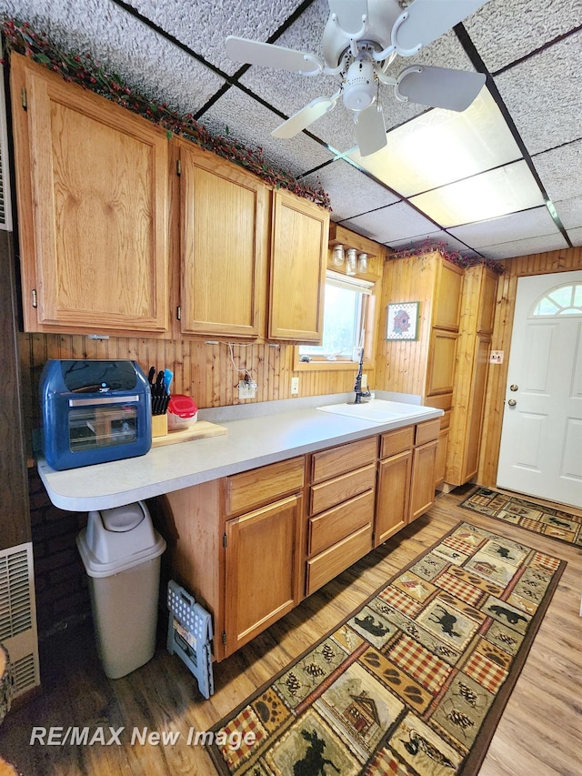 kitchen featuring a sink, light countertops, ceiling fan, and light wood-style flooring