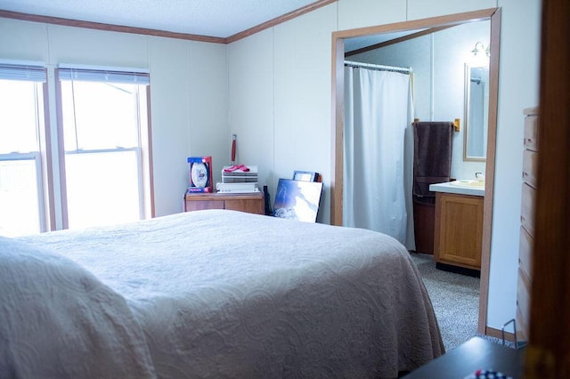 bedroom with carpet flooring, a textured ceiling, ornamental molding, and a decorative wall