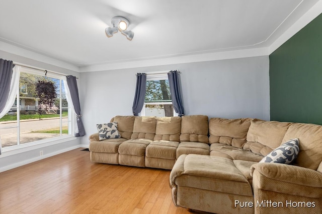living room featuring baseboards, plenty of natural light, and light wood-type flooring
