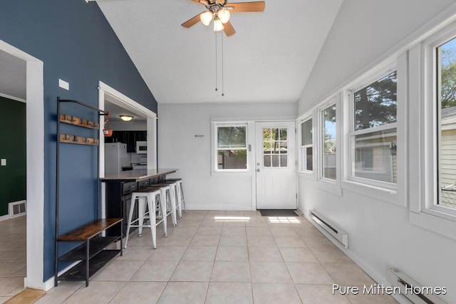 sunroom / solarium with visible vents, a baseboard heating unit, and a wealth of natural light