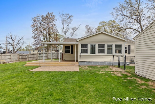 rear view of property featuring a yard, a deck, and a fenced backyard