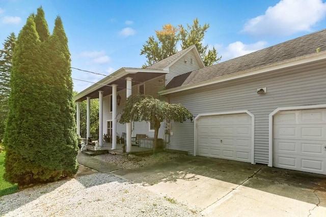 6460 E Galien Buchanan Rd, Buchanan, MI 49107 - view of home's exterior featuring a garage, roof with shingles, driveway, and covered porch