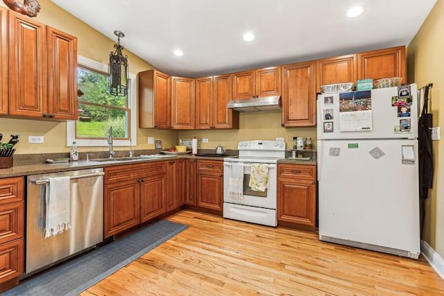 6460 E Galien Buchanan Rd, Buchanan, MI 49107 - kitchen featuring white appliances, under cabinet range hood, brown cabinetry, and a sink