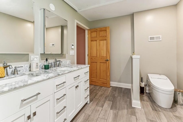 6460 E Galien Buchanan Rd, Buchanan, MI 49107 - full bathroom featuring visible vents, a sink, wood finished floors, and toilet