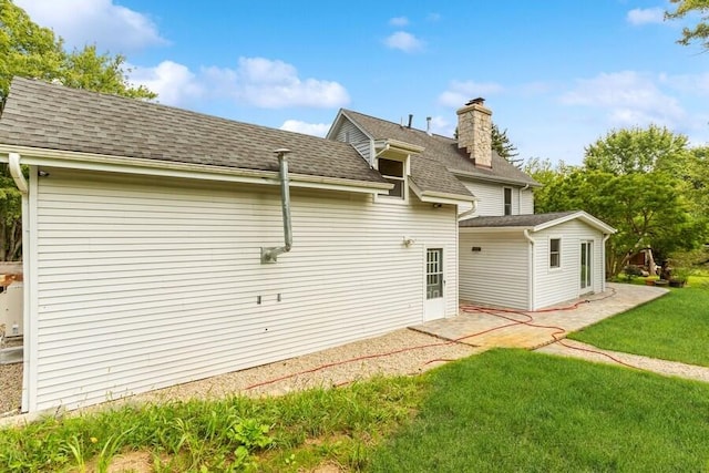 6460 E Galien Buchanan Rd, Buchanan, MI 49107 - back of property with a lawn, a shingled roof, and a chimney