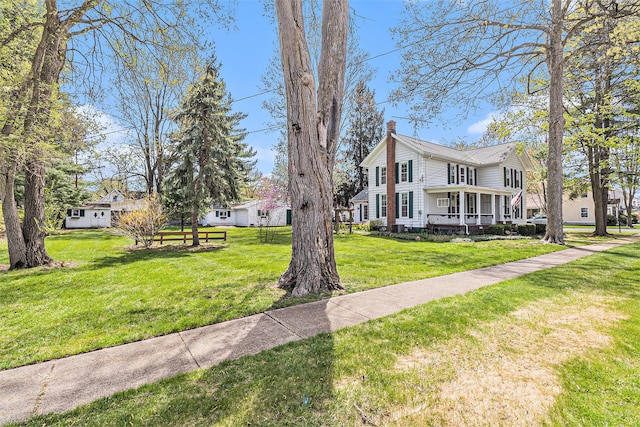 310 E Unadilla St, Pinckney, MI 48169 - view of front facade with covered porch, a chimney, and a front lawn