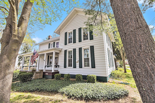 310 E Unadilla St, Pinckney, MI 48169 - view of front of house featuring covered porch and a chimney