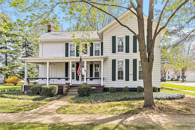310 E Unadilla St, Pinckney, MI 48169 - traditional home featuring covered porch, board and batten siding, and a chimney