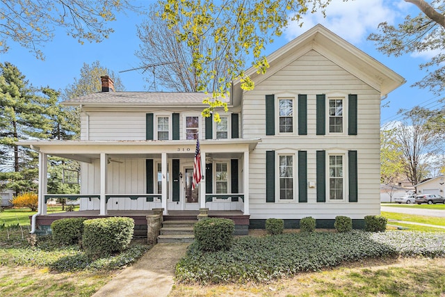 310 E Unadilla St, Pinckney, MI 48169 - view of front of house with board and batten siding, covered porch, and a chimney