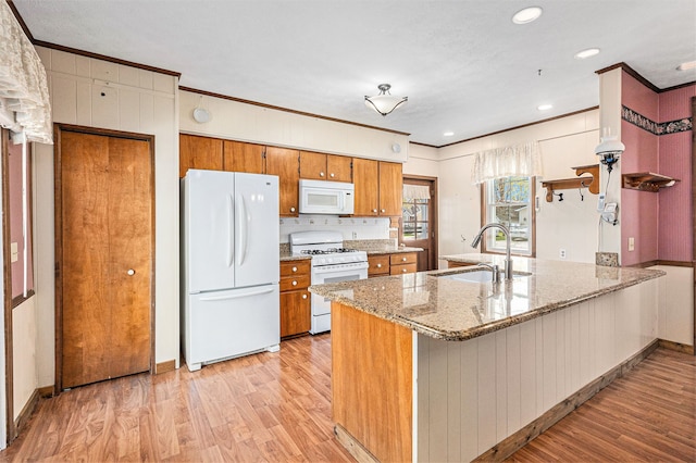 310 E Unadilla St, Pinckney, MI 48169 - kitchen featuring brown cabinets, a sink, light wood finished floors, ornamental molding, and white appliances