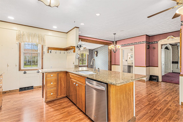 310 E Unadilla St, Pinckney, MI 48169 - kitchen with stainless steel dishwasher, brown cabinetry, a sink, light wood finished floors, and ceiling fan with notable chandelier