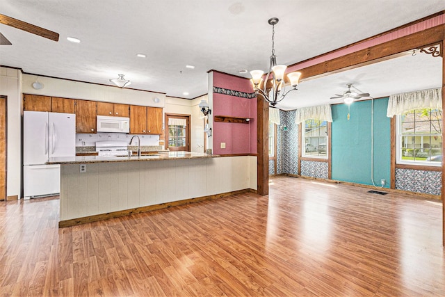 310 E Unadilla St, Pinckney, MI 48169 - kitchen featuring brown cabinets, light wood-type flooring, a sink, ceiling fan with notable chandelier, and white appliances