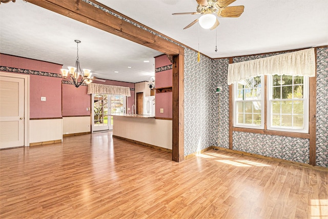 310 E Unadilla St, Pinckney, MI 48169 - spare room with a sink, light wood-style floors, ceiling fan with notable chandelier, wallpapered walls, and baseboards