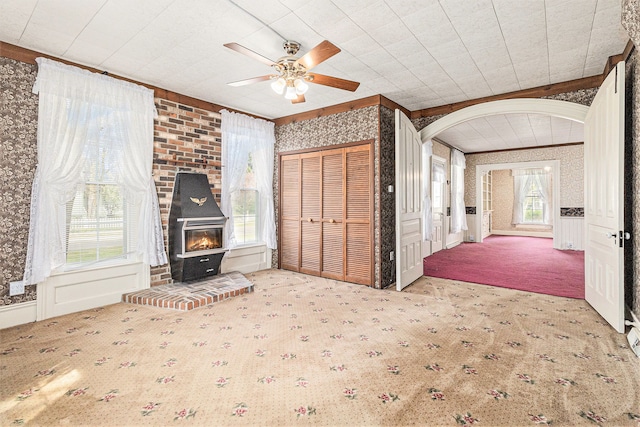 310 E Unadilla St, Pinckney, MI 48169 - unfurnished living room featuring carpet flooring, arched walkways, wallpapered walls, and ceiling fan
