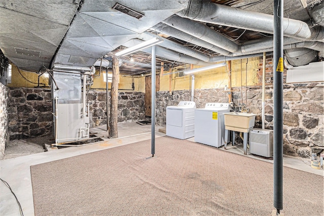 310 E Unadilla St, Pinckney, MI 48169 - unfinished basement with separate washer and dryer, a sink, heating unit, and visible vents