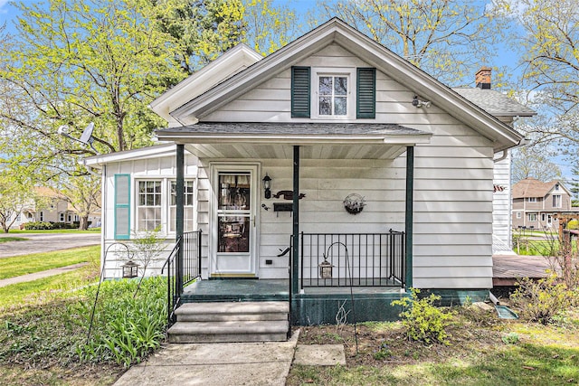 310 E Unadilla St, Pinckney, MI 48169 - view of front of property featuring roof with shingles, a chimney, and a porch
