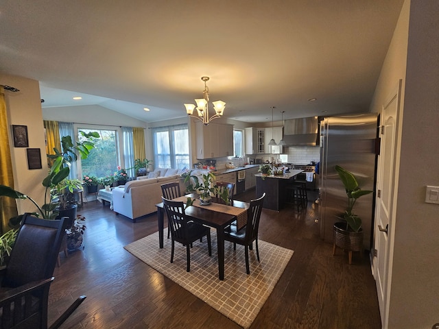 dining space with recessed lighting, lofted ceiling, dark wood finished floors, and a chandelier