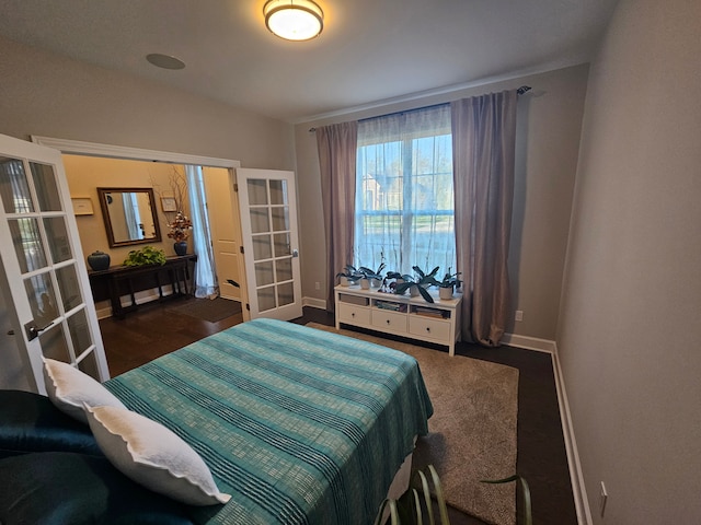 bedroom with baseboards, french doors, and wood finished floors