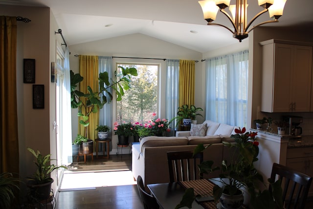 dining space featuring a notable chandelier, wood finished floors, and lofted ceiling