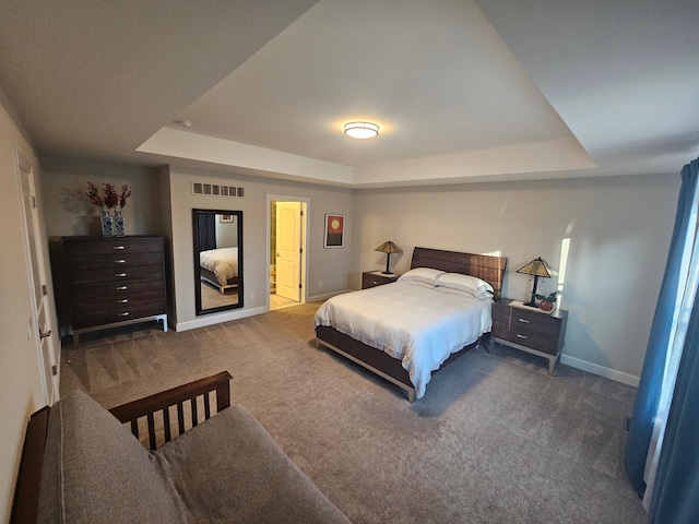 bedroom featuring carpet floors, a tray ceiling, visible vents, and baseboards