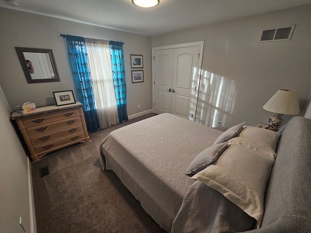 carpeted bedroom featuring baseboards, a closet, and visible vents
