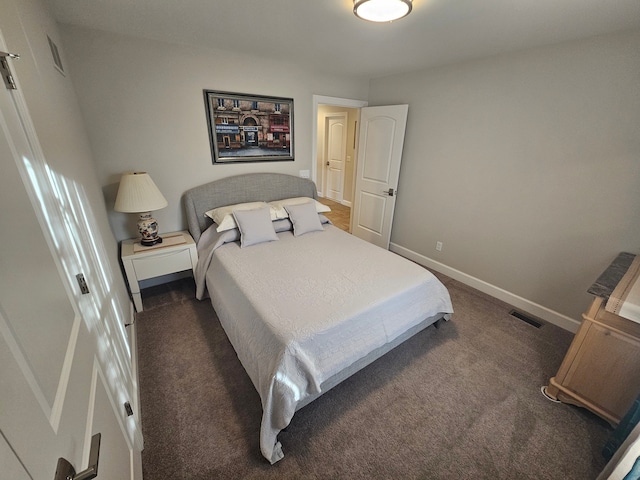 bedroom with baseboards, visible vents, and dark colored carpet