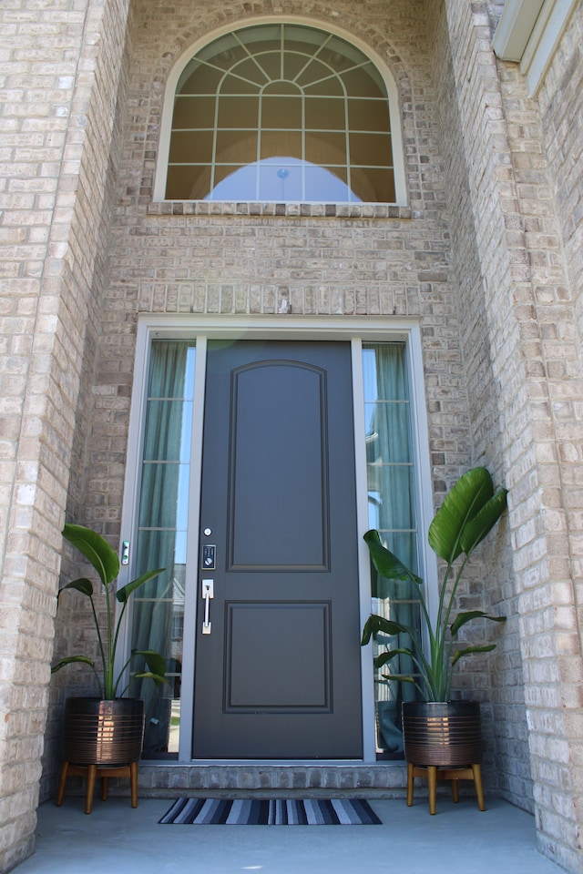 view of exterior entry with brick siding