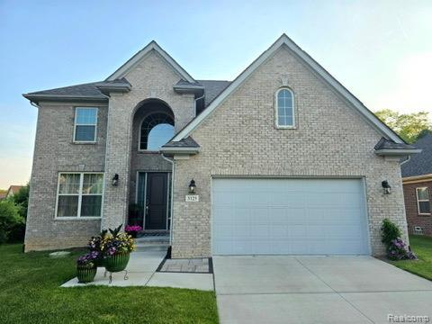 3125 Fortune Ln, Commerce Twp, MI 48390 - view of front of home featuring brick siding, a front lawn, and driveway