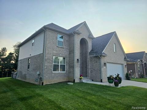 3125 Fortune Ln, Commerce Twp, MI 48390 - traditional-style house with a front lawn, driveway, and brick siding