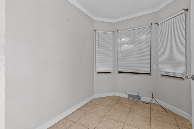 empty room featuring light tile patterned flooring, baseboards, visible vents, and ornamental molding