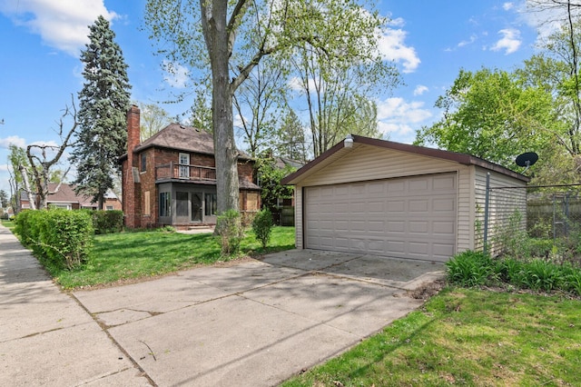 view of front of house featuring fence, brick siding, a garage, a front yard, and an outbuilding