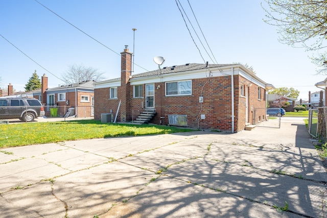 31825 Eveningside, Fraser, MI 48026 - rear view of property featuring cooling unit, brick siding, a chimney, entry steps, and driveway