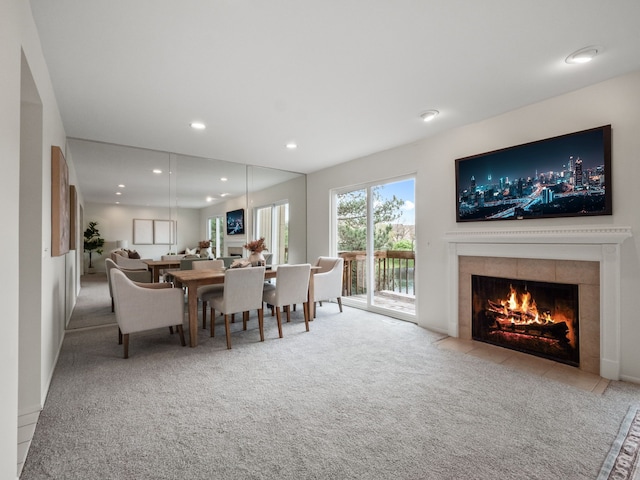 dining room with a tiled fireplace, carpet, and recessed lighting