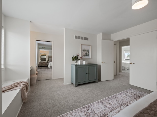 corridor featuring light colored carpet and visible vents