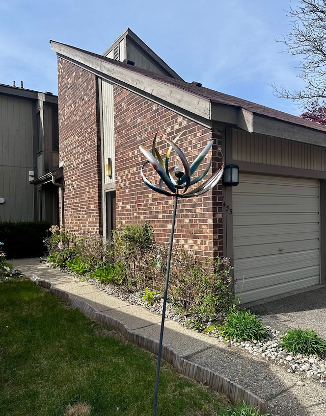 view of side of property featuring brick siding and an attached garage