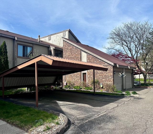 view of property exterior with covered parking and brick siding