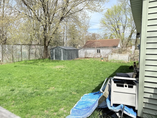 view of yard featuring fence, an outbuilding, and a storage unit