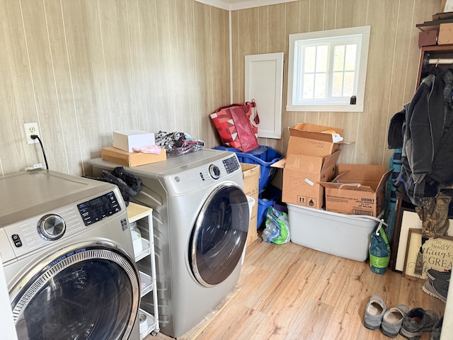 washroom featuring wooden walls, laundry area, independent washer and dryer, and wood finished floors