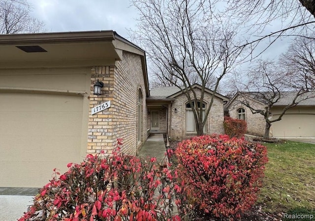 exterior space featuring brick siding and an attached garage