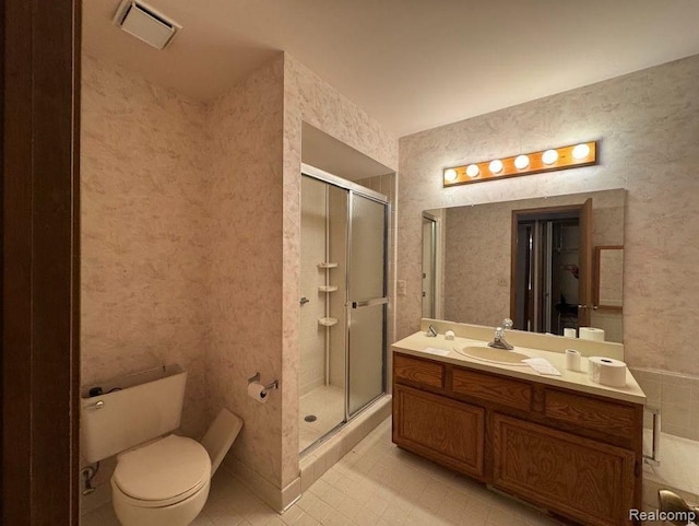bathroom with vanity, a shower stall, toilet, and visible vents
