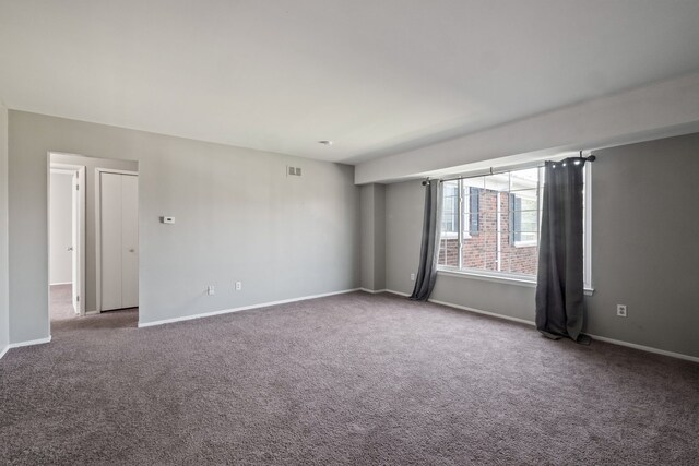 carpeted spare room featuring baseboards