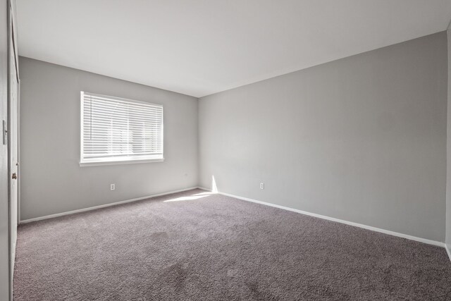 carpeted spare room with baseboards