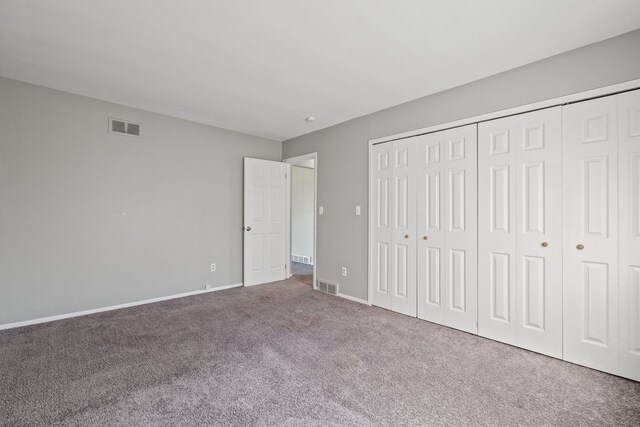unfurnished bedroom featuring baseboards, visible vents, carpet, and a closet