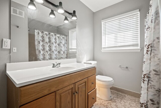 bathroom featuring vanity, toilet, baseboards, a shower with curtain, and visible vents