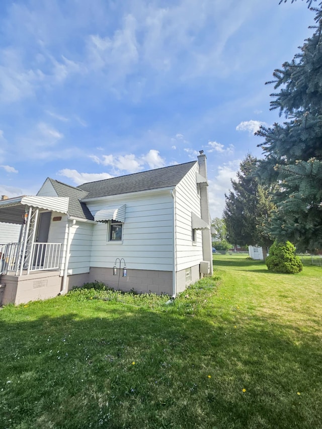 4010 Stolzenfeld Ave, Warren, MI 48091 - view of side of home with roof with shingles, a yard, a chimney, and covered porch
