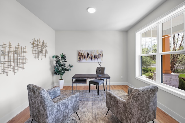 sitting room featuring a desk, baseboards, and wood finished floors