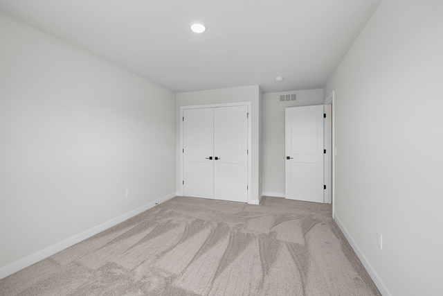 unfurnished bedroom featuring baseboards, carpet, a closet, and recessed lighting