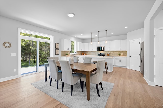 dining space with light wood-style flooring, baseboards, and recessed lighting