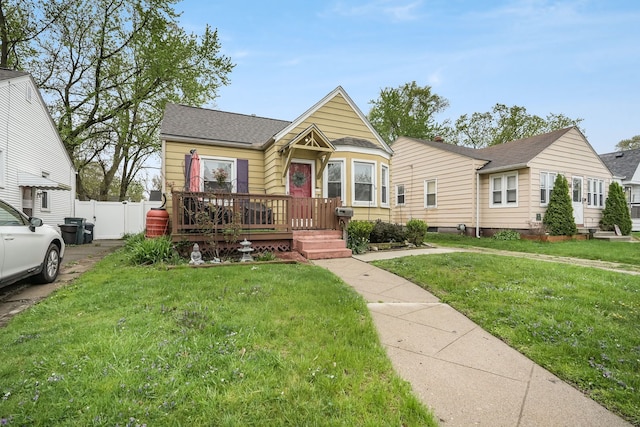 1343 Northway St, Ferndale, MI 48220 - bungalow-style house featuring a shingled roof, a front lawn, and fence